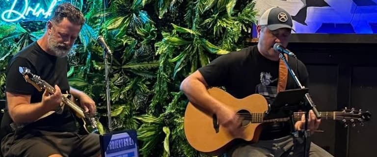 Kevin and Chris playing acoustic at a bar